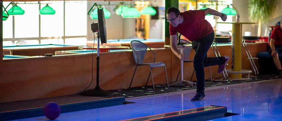 Mann beim Bowling in einer Indoor-Bahn.