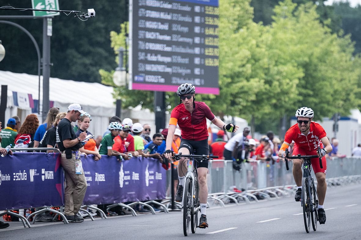 Zwei Radfahrer bei einem Wettkampf mit Zuschauern.