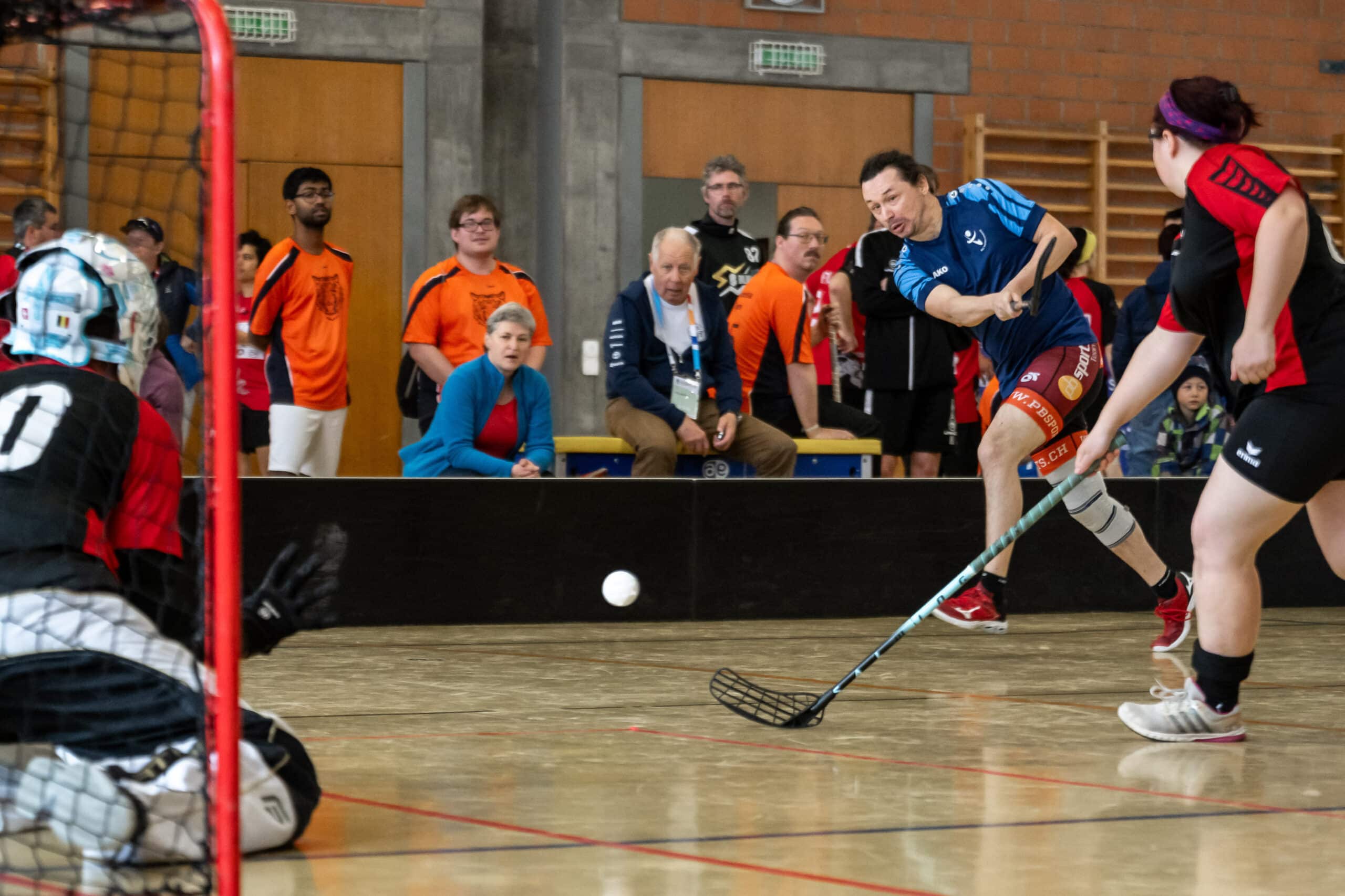 Indoor-Sportler beim Spiel mit Zuschauergruppen.
