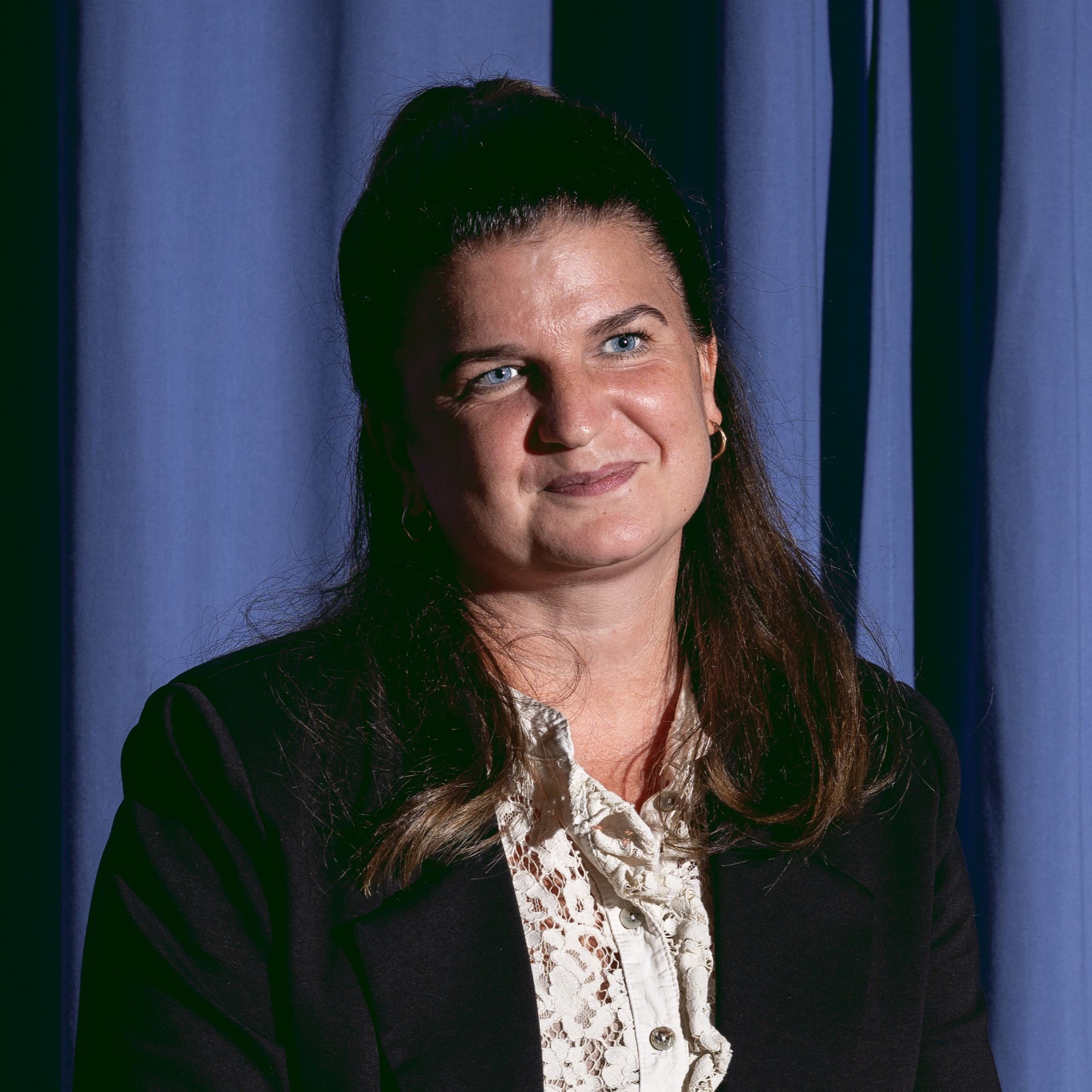 Frau mit blauer Kulisse lächelnd