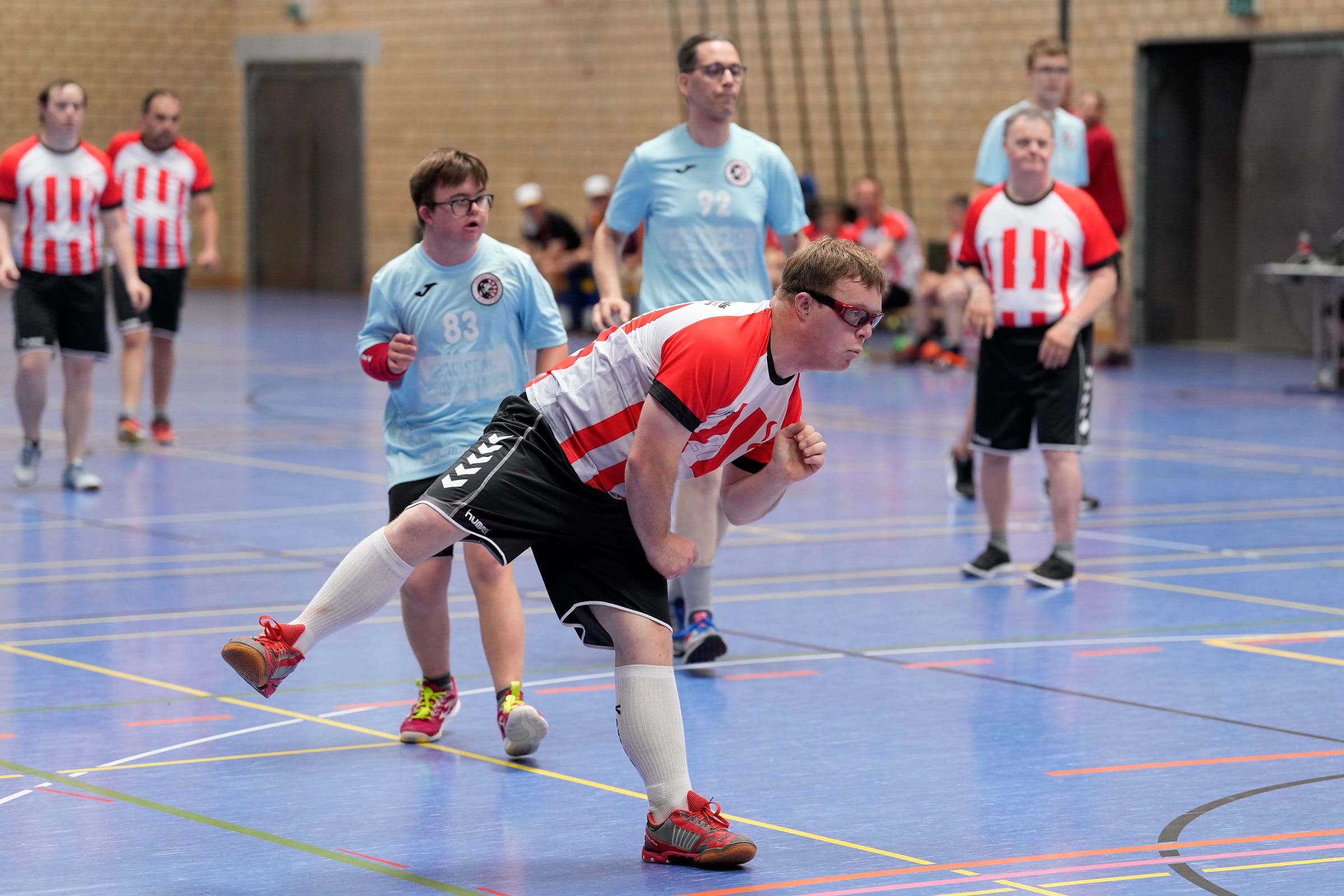 Handballspiel in Turnhalle mit Spielern in Aktion