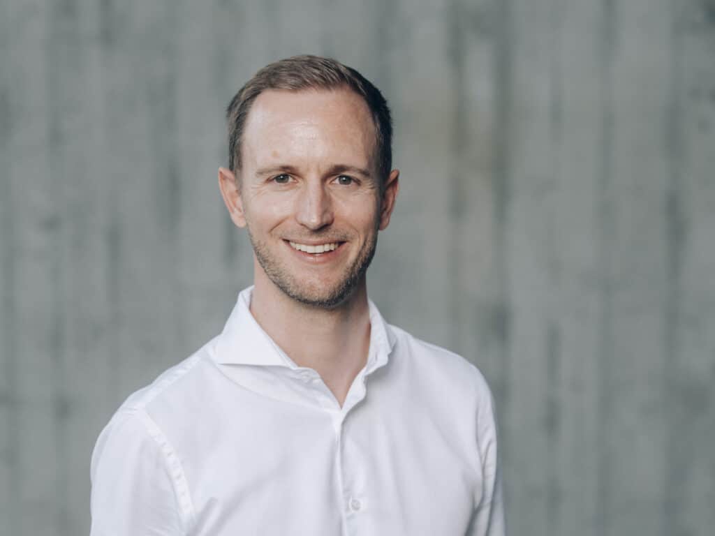 Mann in weissem Hemd vor grauem Hintergrund
