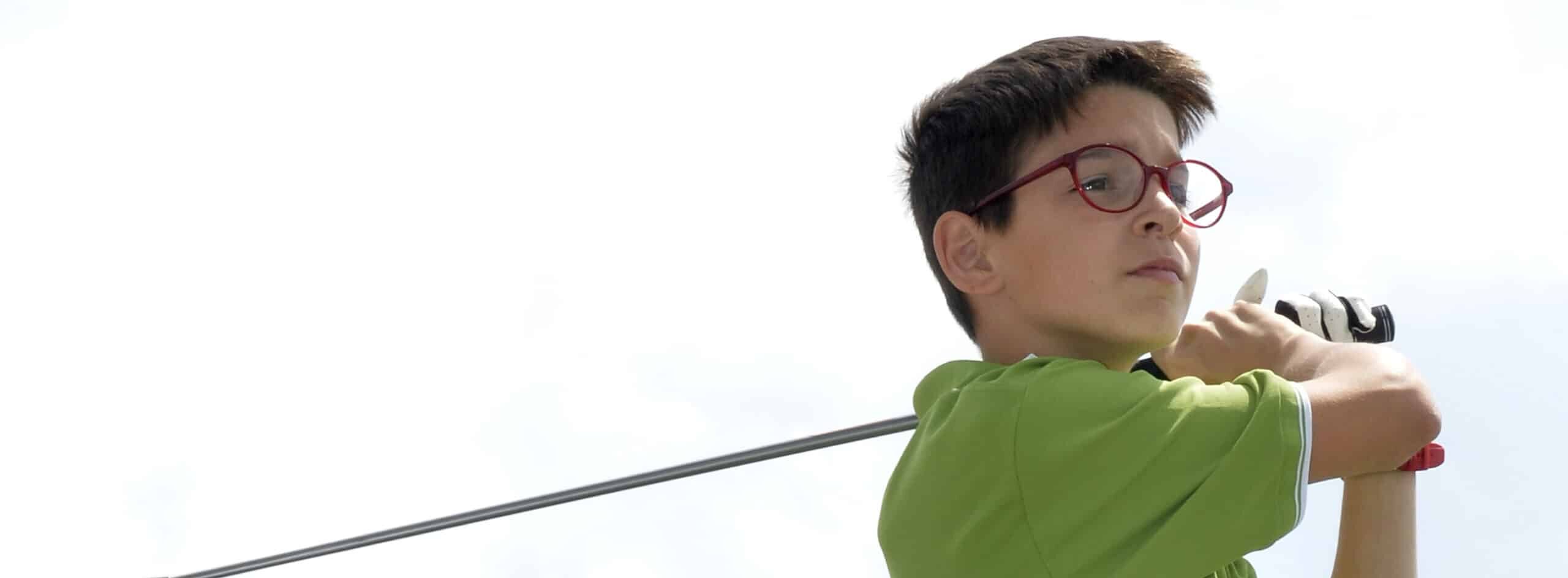 Junge mit Golfschläger auf dem Golfplatz