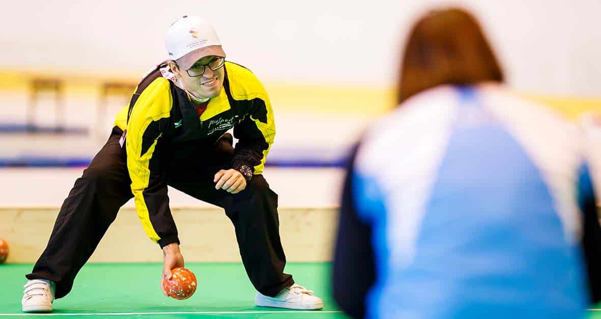 Mann spielt mit einer Kugel Boccia