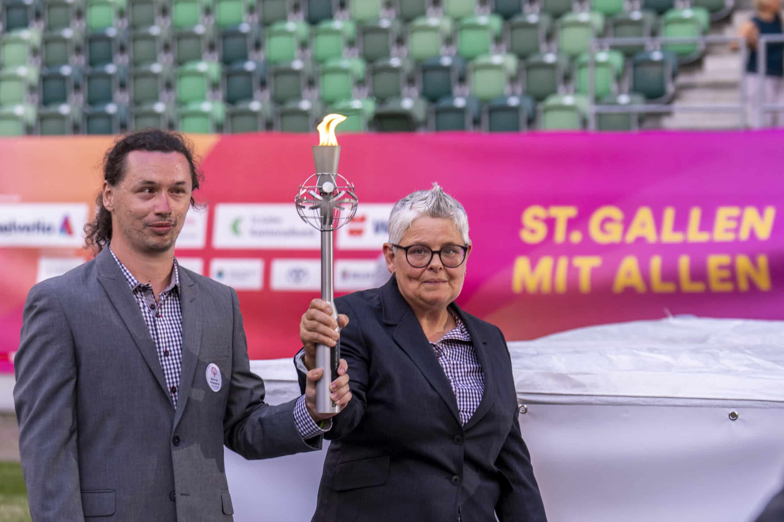 Zwei Personen halten eine Fackel bei Event.