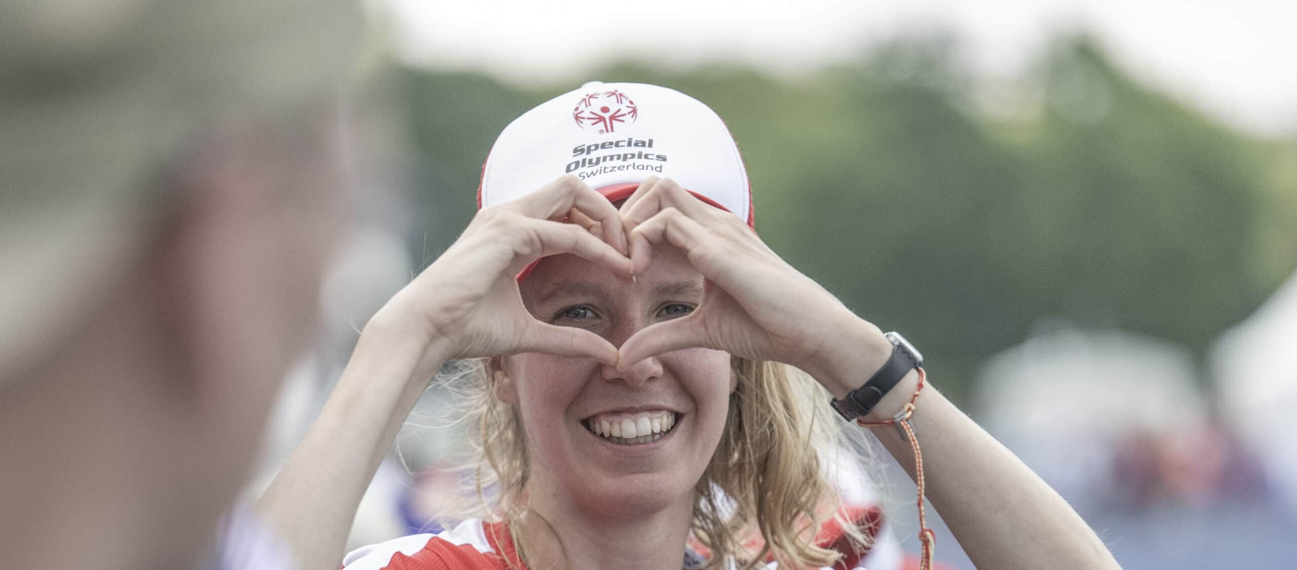 Sportlerin bildet ein Herz mit Händen.