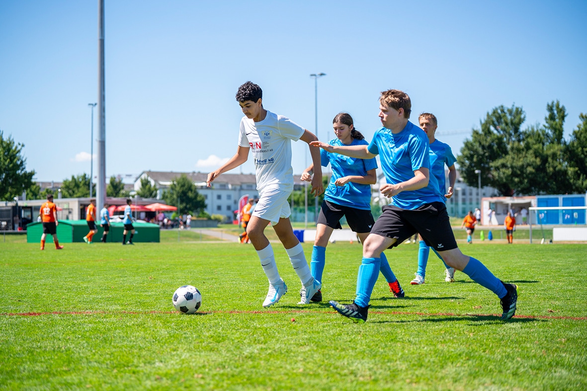 Kinder spielen Fußball auf dem Platz.