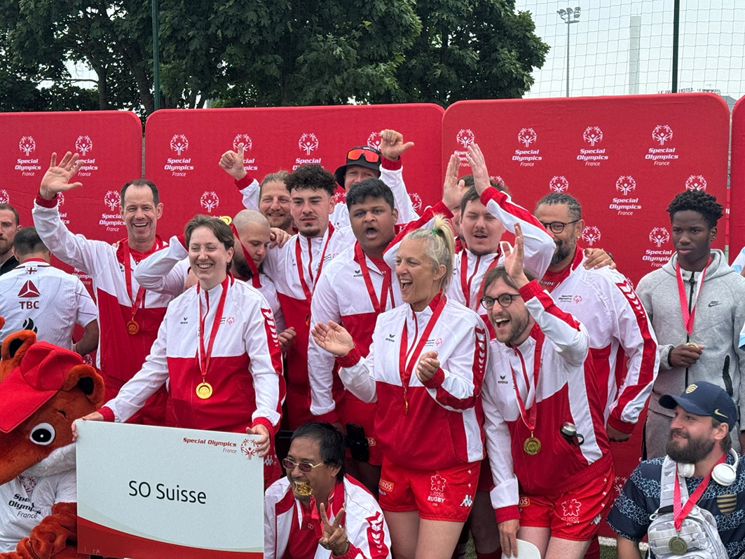 Sportlerteam mit Medaillen feiert Erfolge.