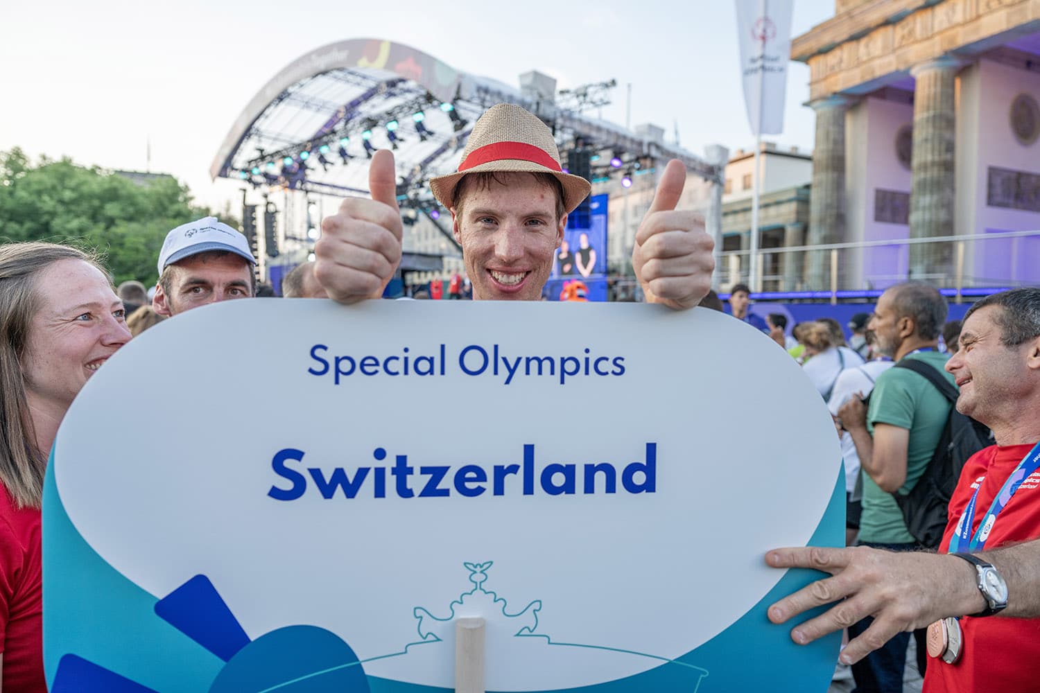 Teilnehmer präsentiert Schild von Special Olympics Schweiz.