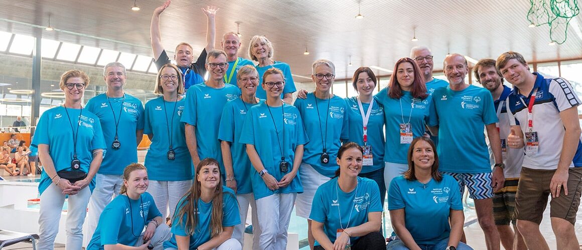 Gruppe von Personen posiert in blauen T-Shirts.