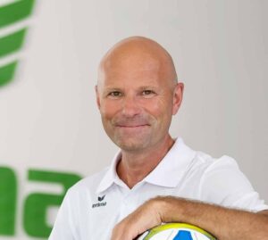 Mann mit Fußball vor Erima-Logo