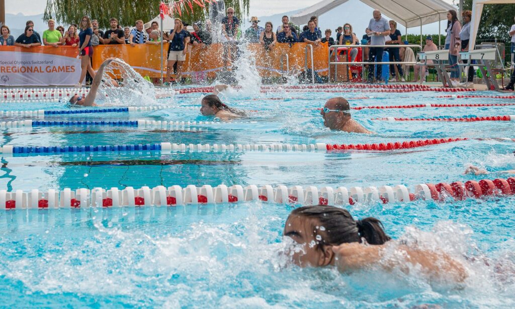 Schwimmwettkampf mit Teilnehmern im Wasser.