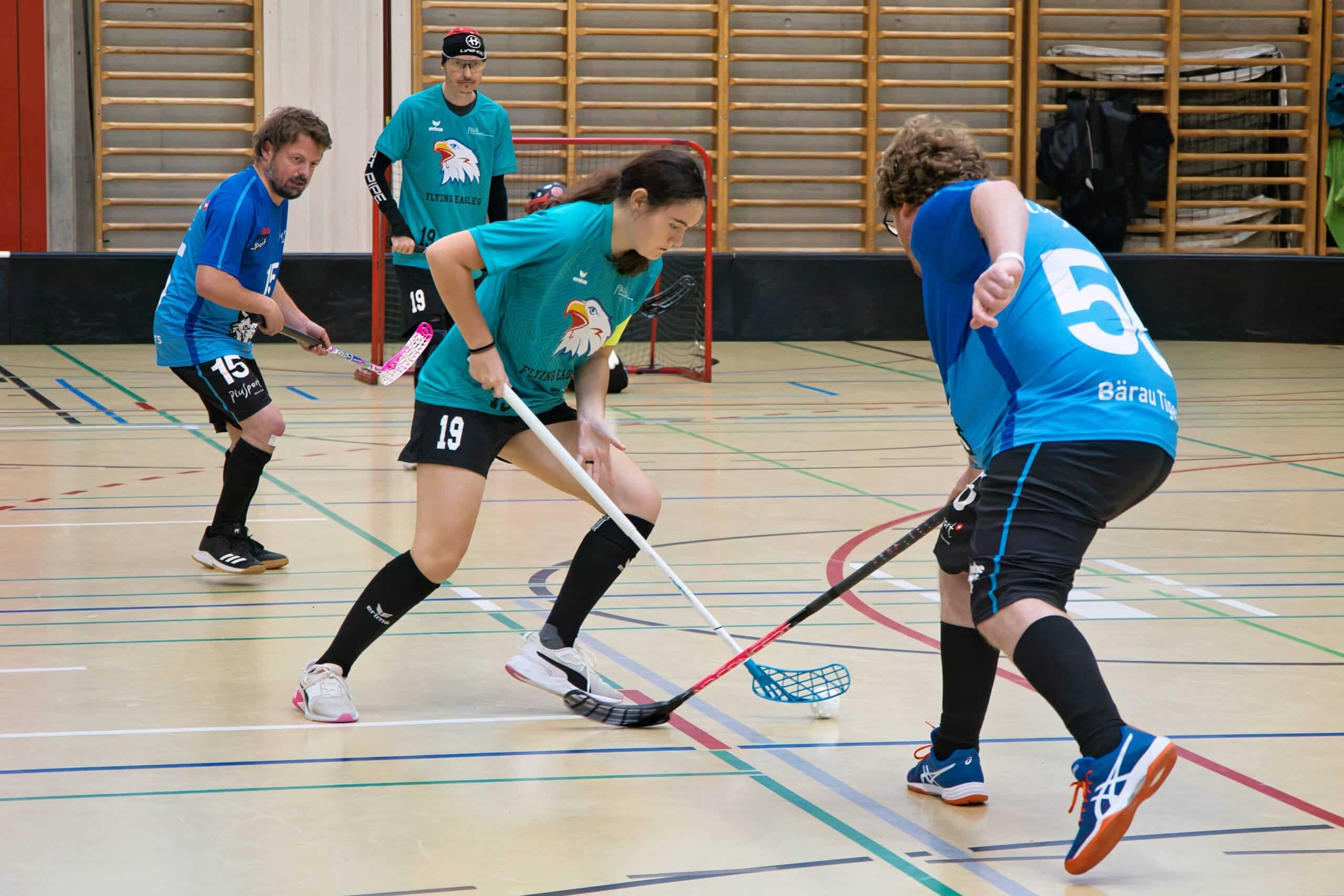 Zwei Spieler beim Hockey in einer Sporthalle.