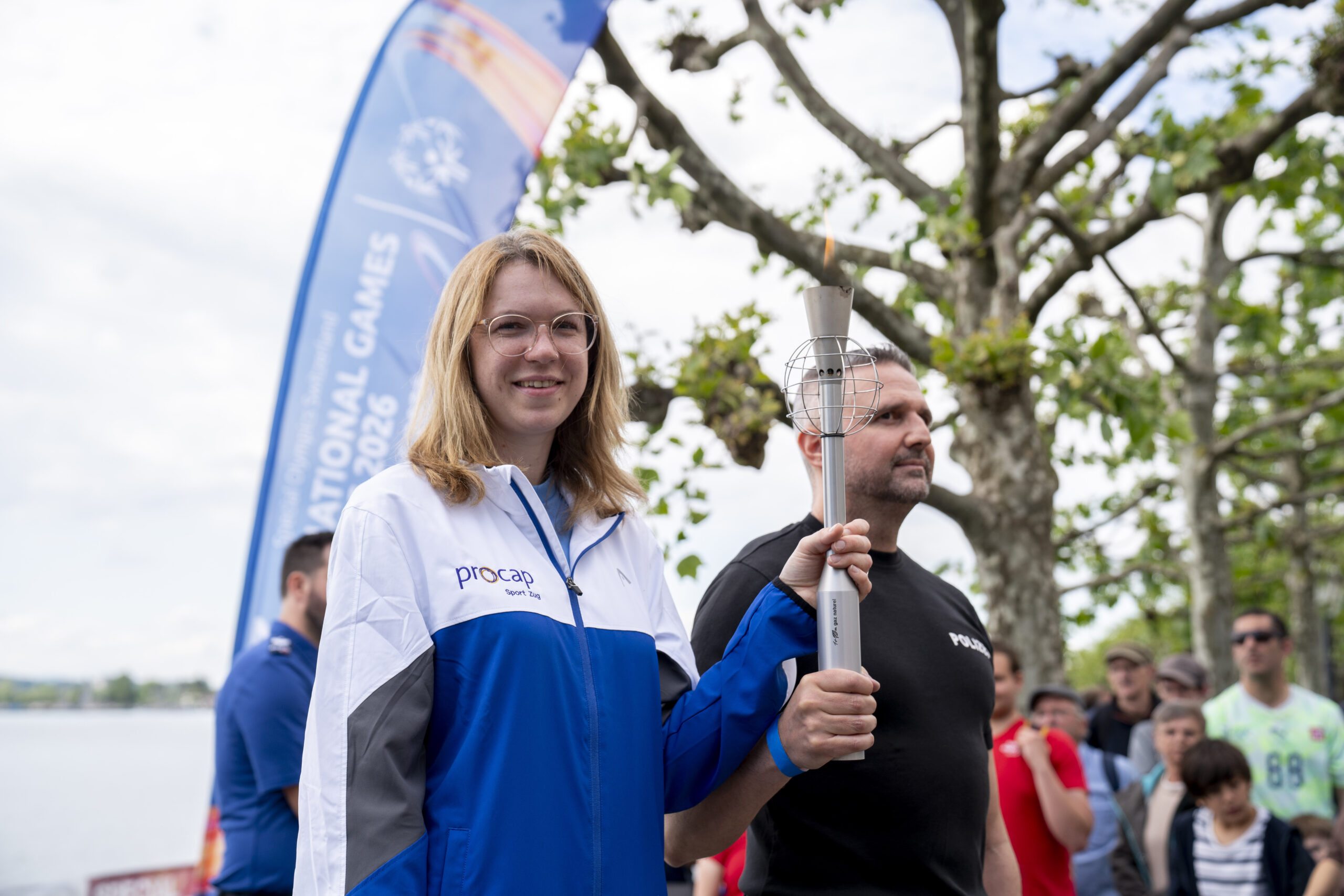 Frau mit Fackel bei Sportveranstaltung im Freien