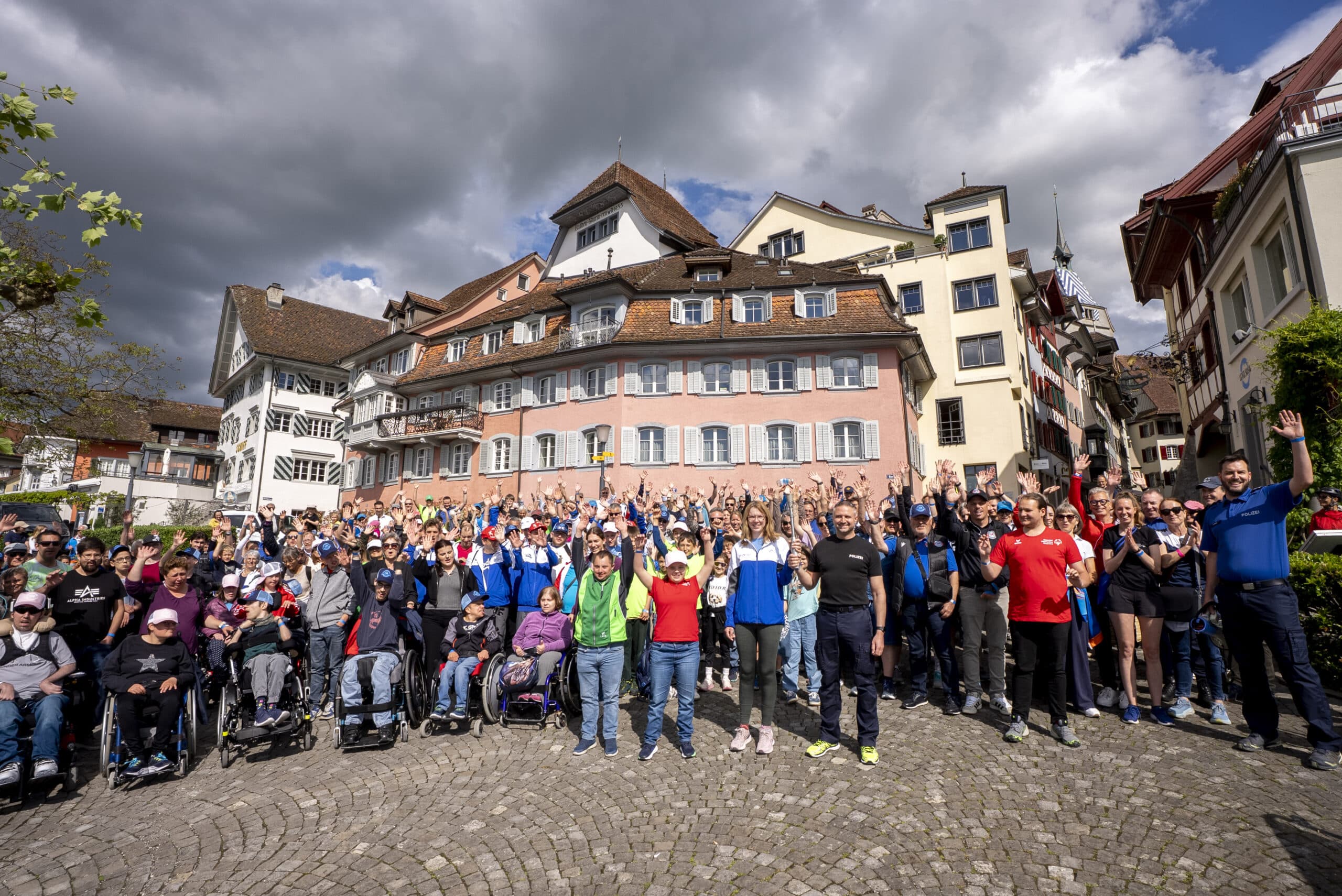 Große Gruppe mit Rollstuhlfahrern auf Marktplatz