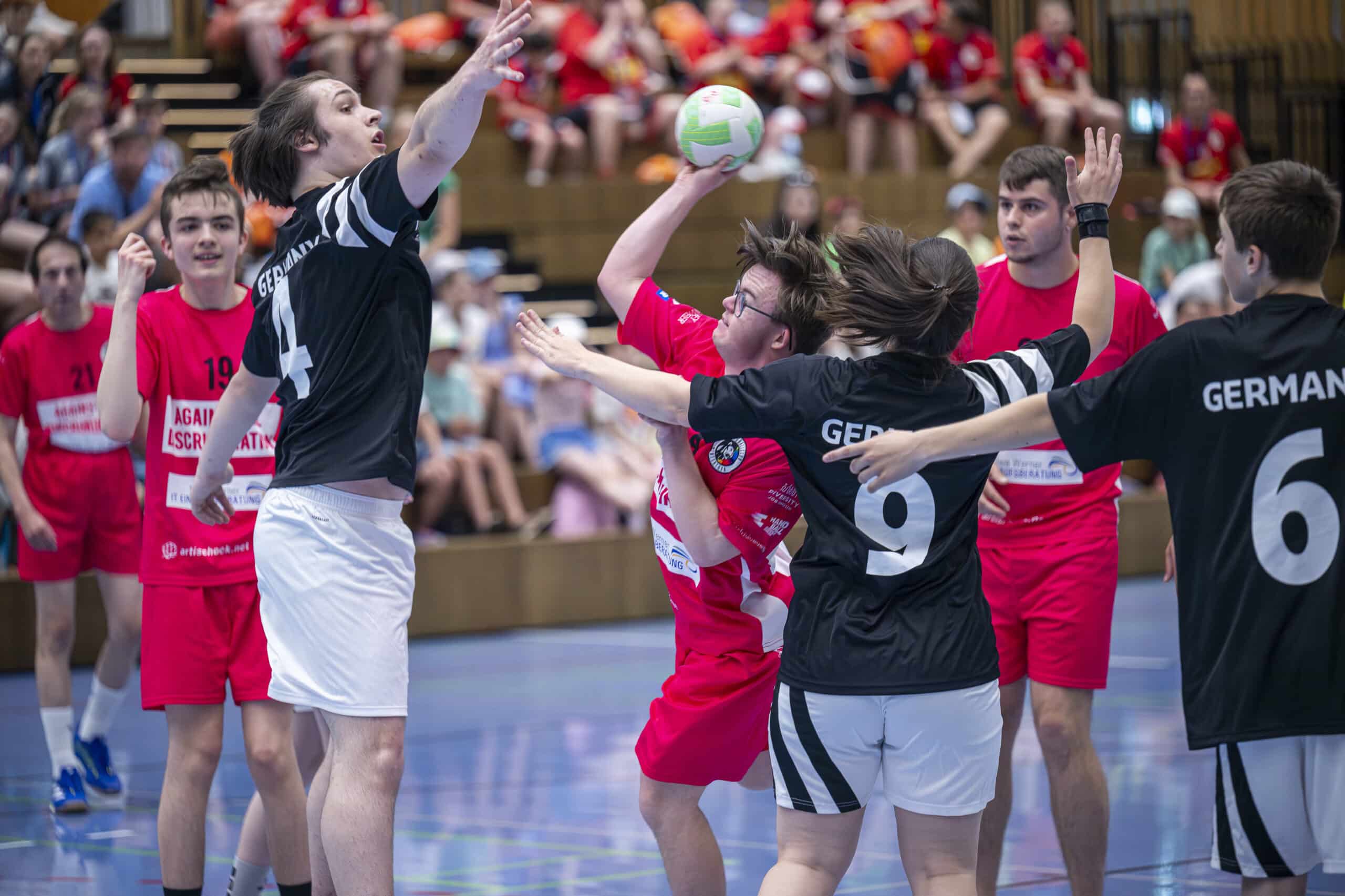 Jugendliche spielen Handball in einer Sporthalle