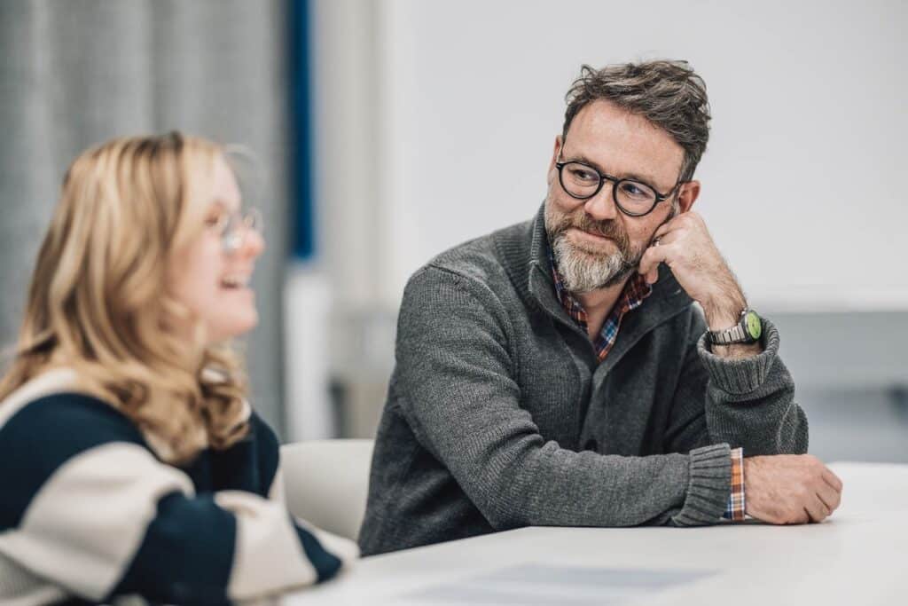 Zwei Personen im Gespräch am Tisch
